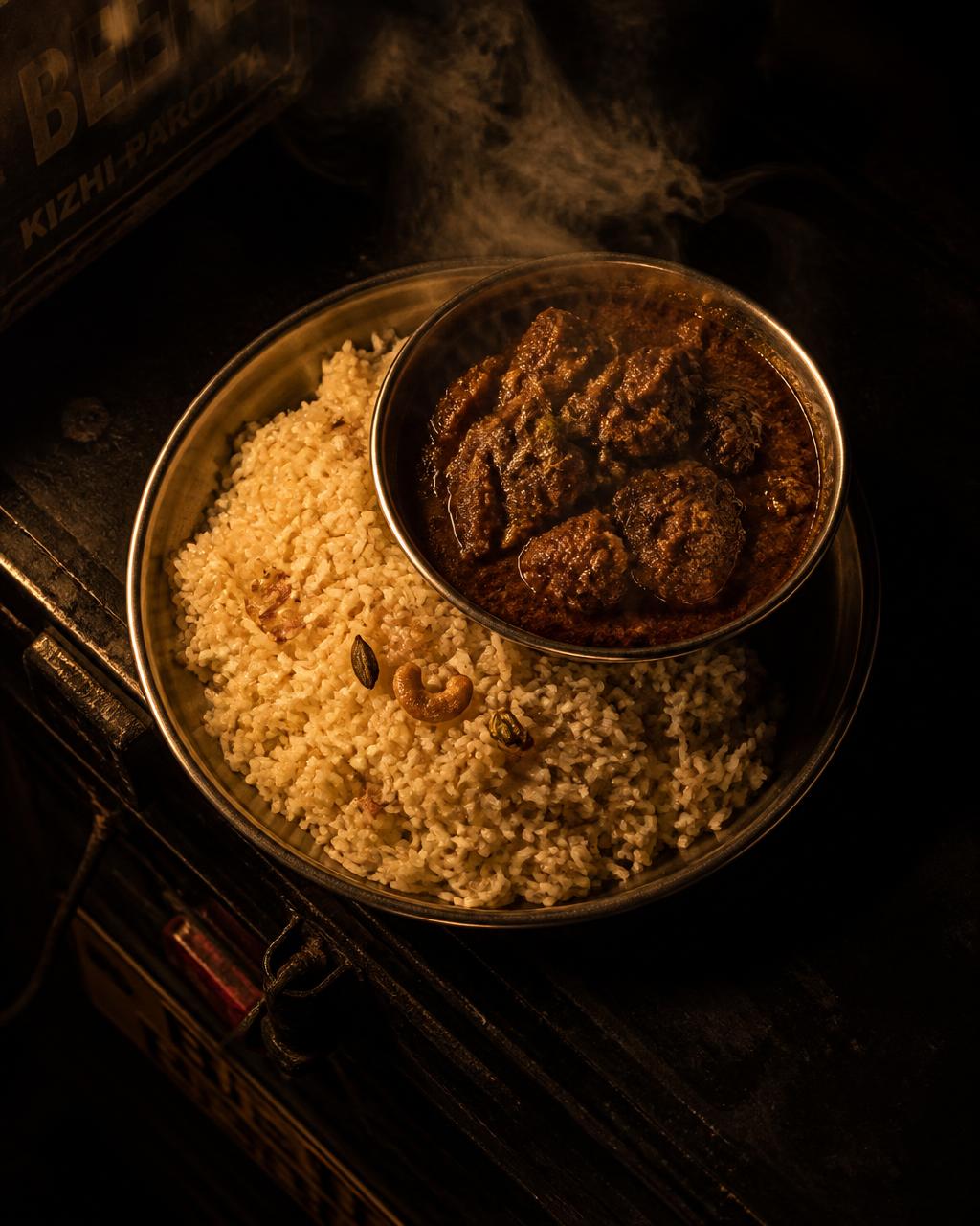 Ghee rice with slow-cooked beef gravy served on a steel plate